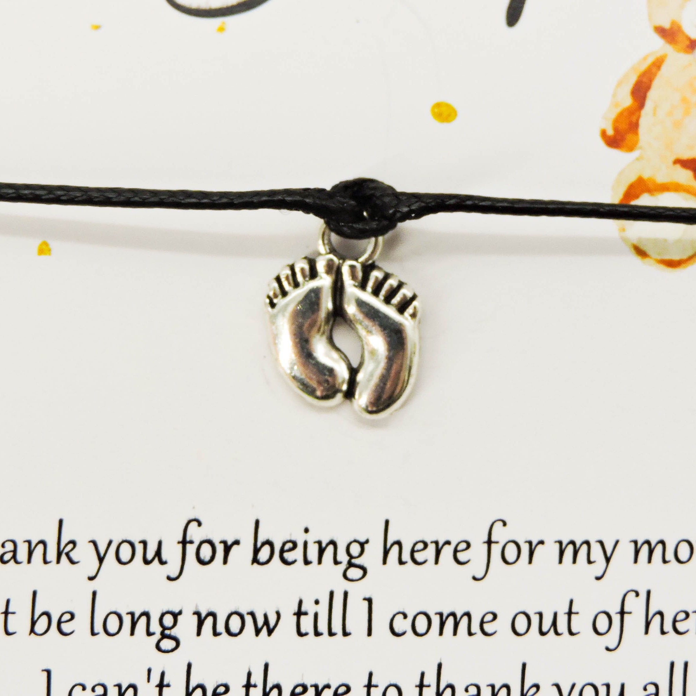 A Message from the Bump Bracelet featuring a close-up of a delicate bracelet with a tiny baby feet charm on a thoughtful message card.