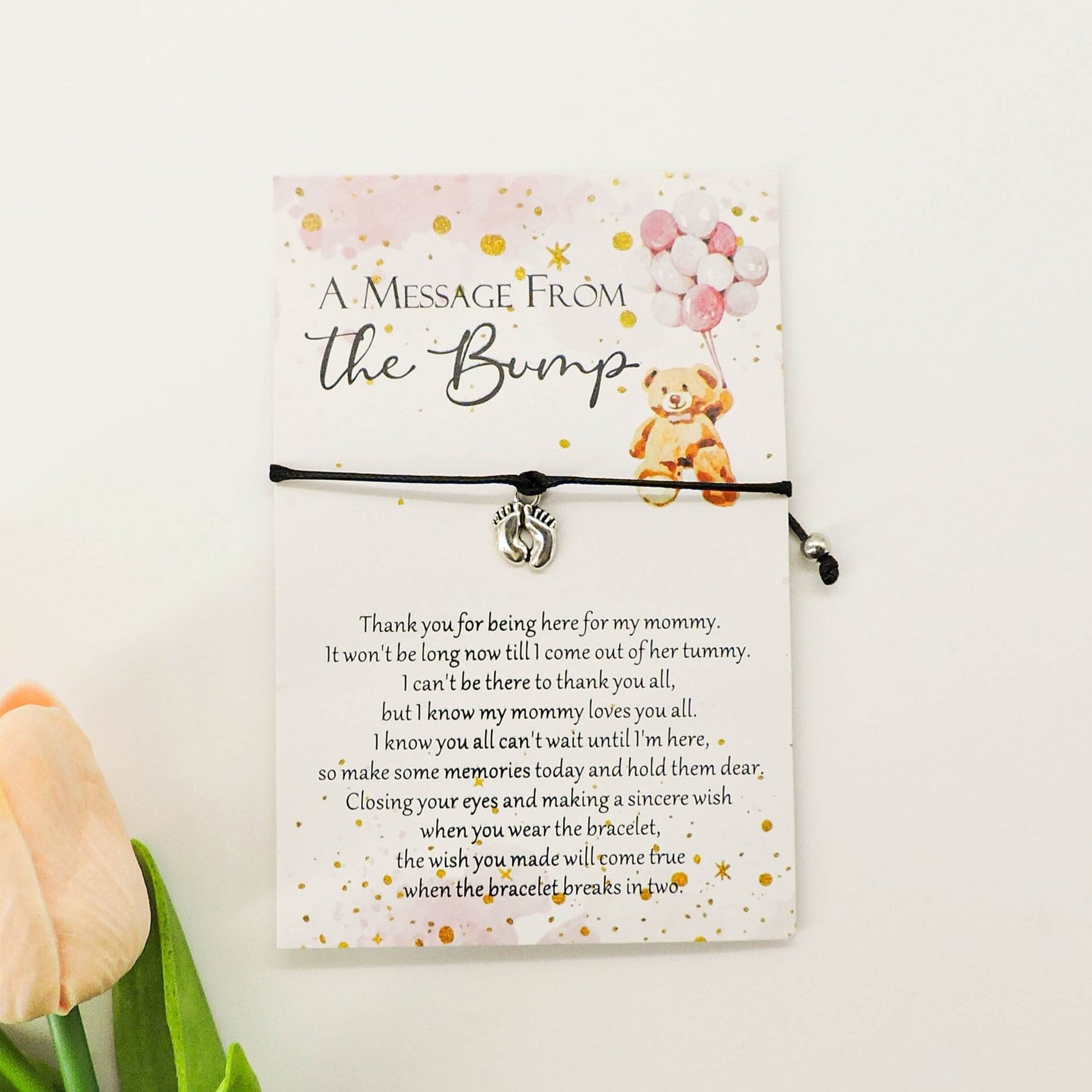 A Message from the Bump Bracelet featuring a delicate bracelet with a tiny baby feet charm on a message card, symbolizing motherhood excitement.