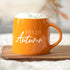 Hello Autumn Mug & Cosy Socks set featuring an orange mug with Hello Autumn text and fluffy white socks, perfect for cozy autumn moments.