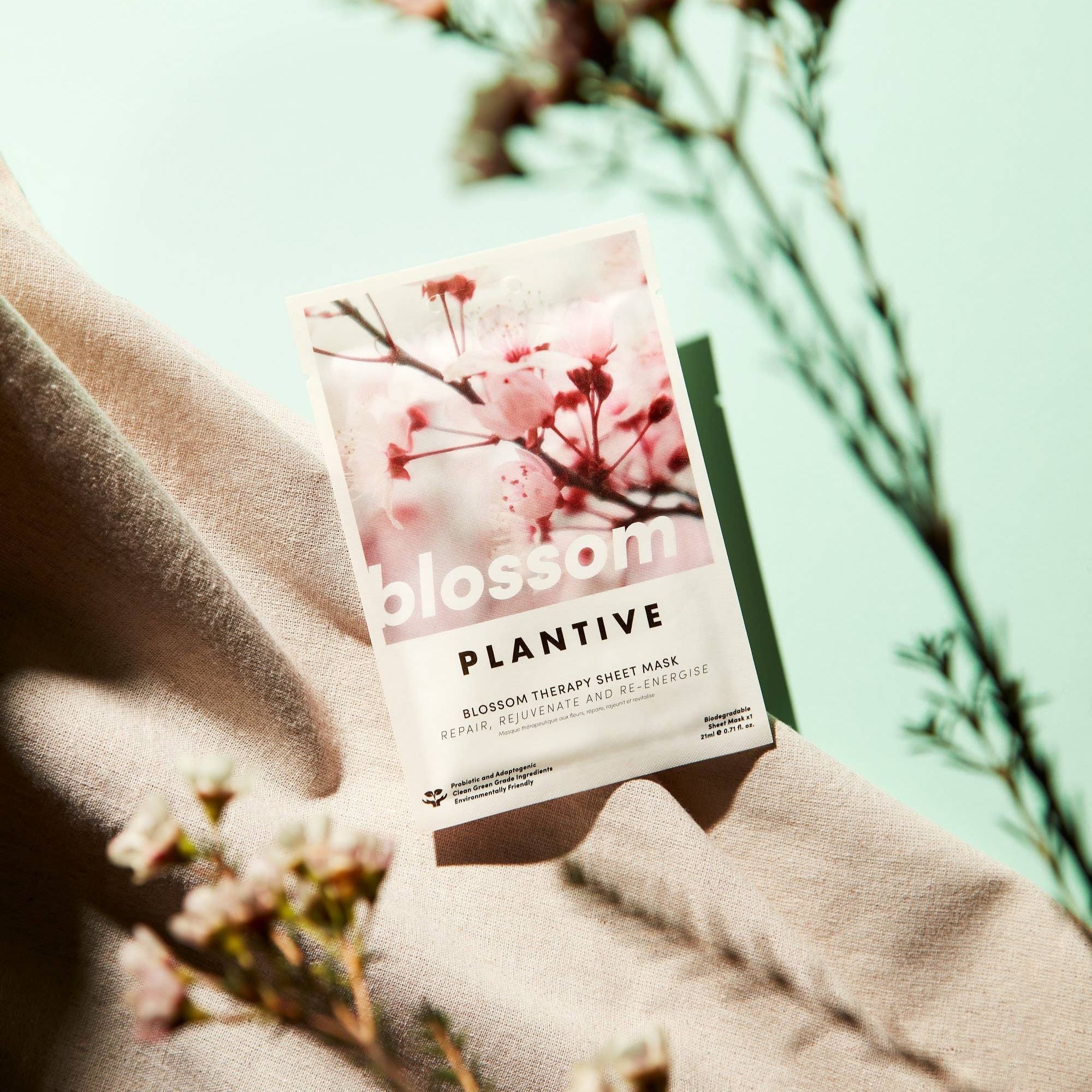 Blossom Therapy Korean Mask featuring close-ups of pink flowers, highlighting its eco-friendly, probiotic, and adaptogenic herb-based formulation for skin rejuvenation and relaxation.