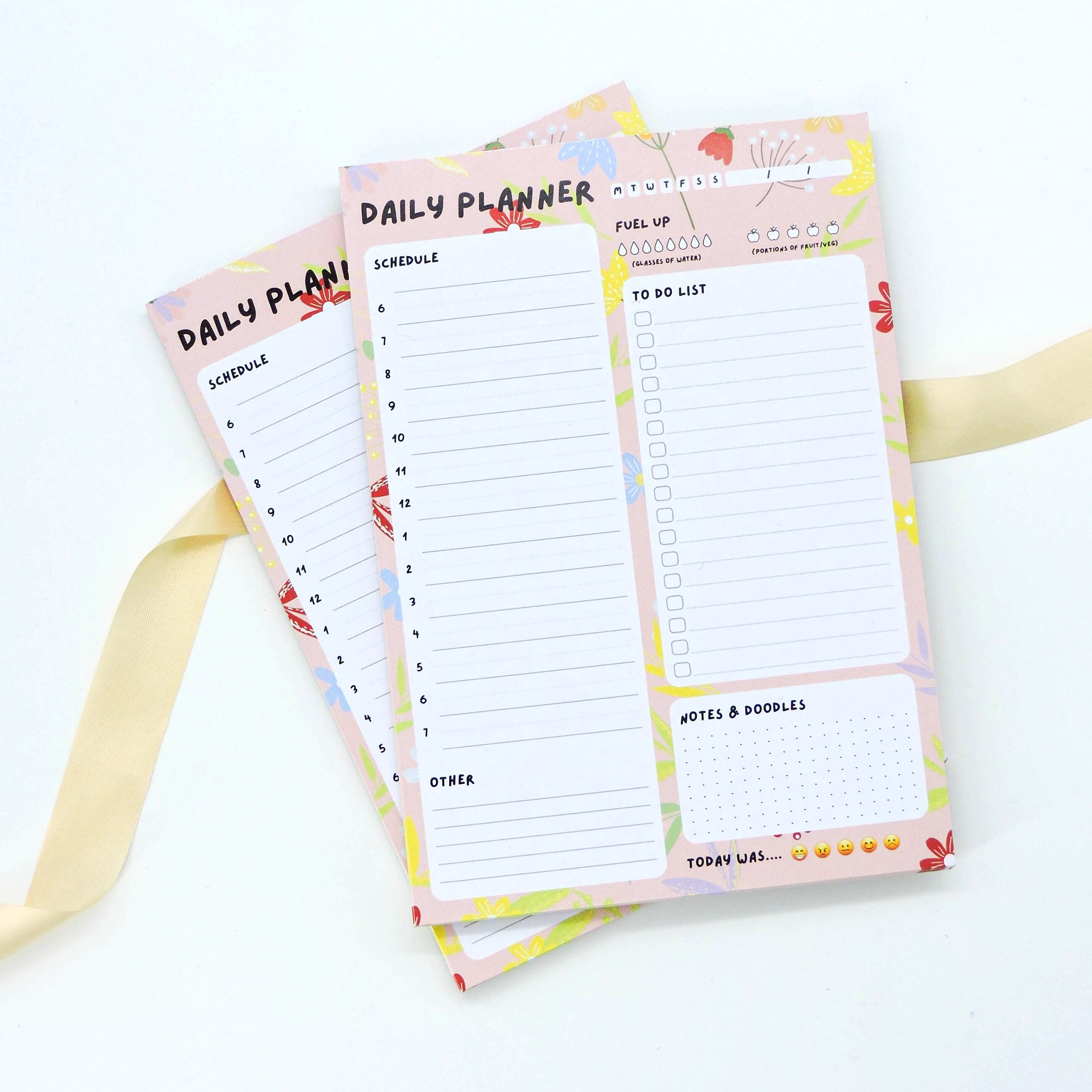Daily Planner A5 Deskpad close-up showing floral layout with sections for scheduling, to-do lists, hydration tracking, and notes for enhanced organization.