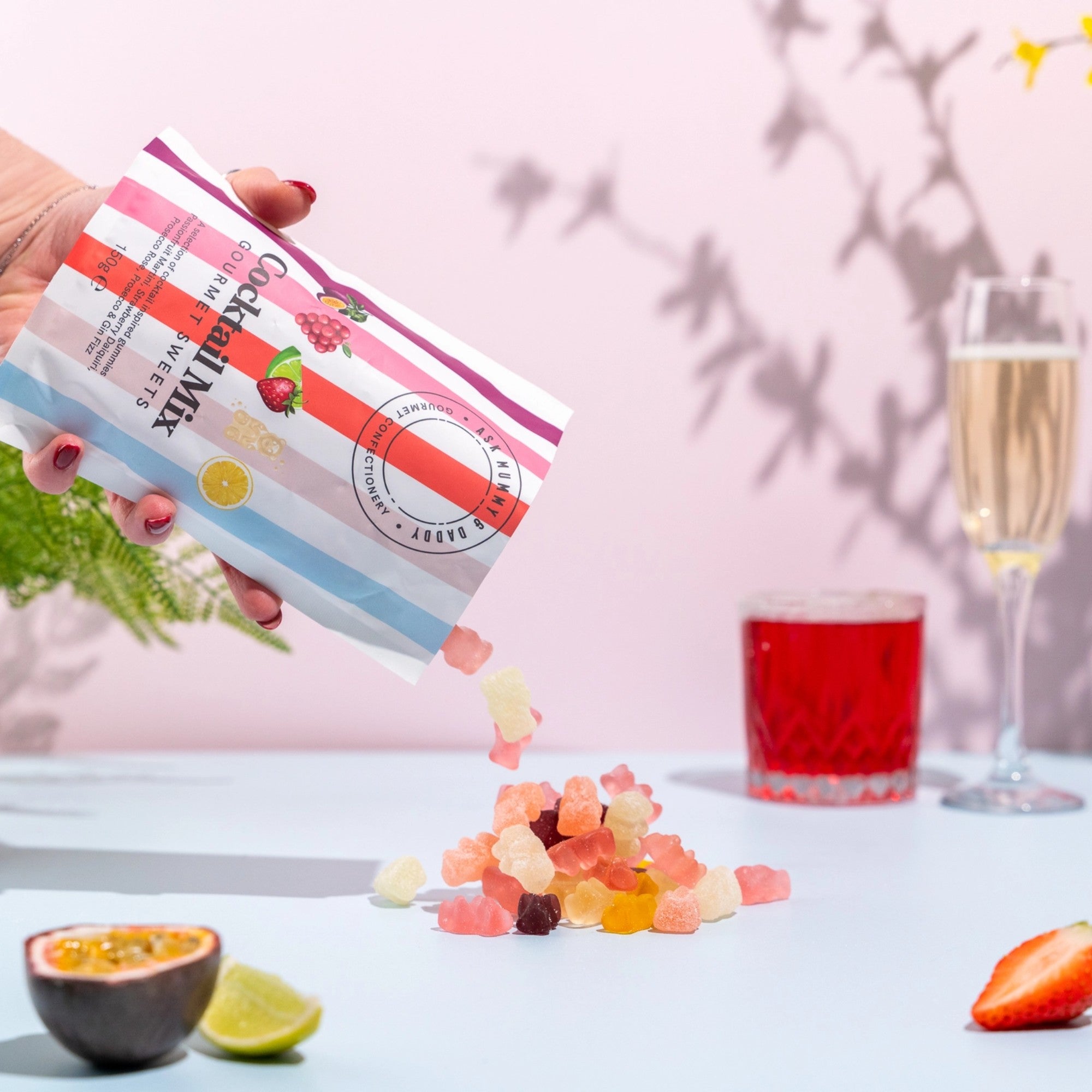 Gifts for her – vibrant gourmet sweets with mixed fruit gummies styled with cocktail drinks and glassware