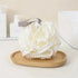 Luxury Loofah - White: A close-up of a white, curved bath loofah on a wooden tray, designed for gentle exfoliation and creating a rich lather.