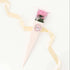 Pink Carnation Soap Flower displayed in a clear box, featuring a close-up of a ribbon and a flower nestled in a cone-shaped bag, showcasing its elegant presentation.