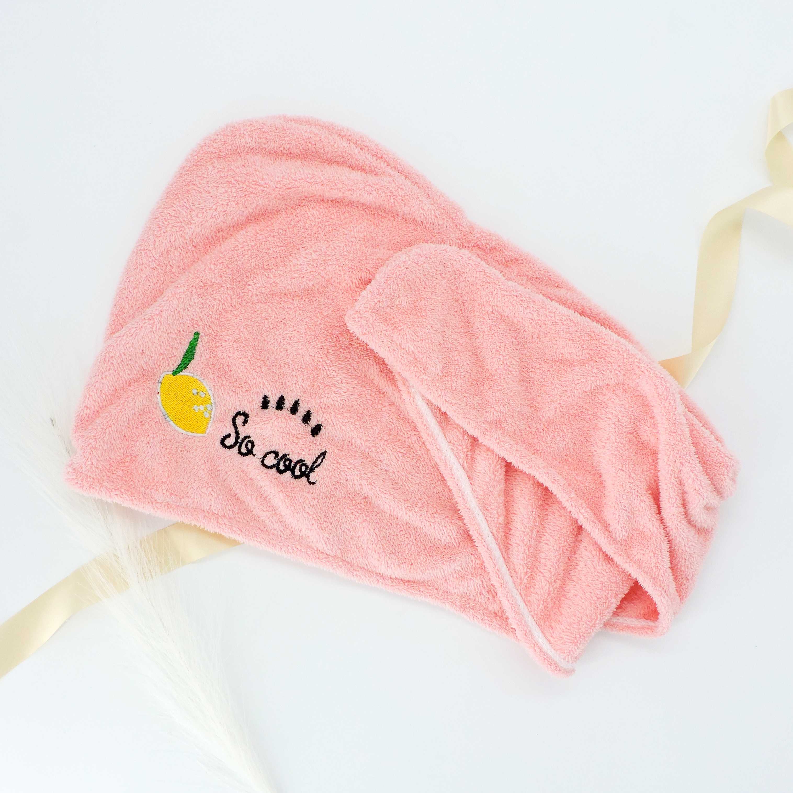 Close-up of the Pink Lemon Hair Towel, showcasing its ultra-soft, absorbent fabric with an embroidered lemon design, ideal for reducing frizz and secure everyday use.