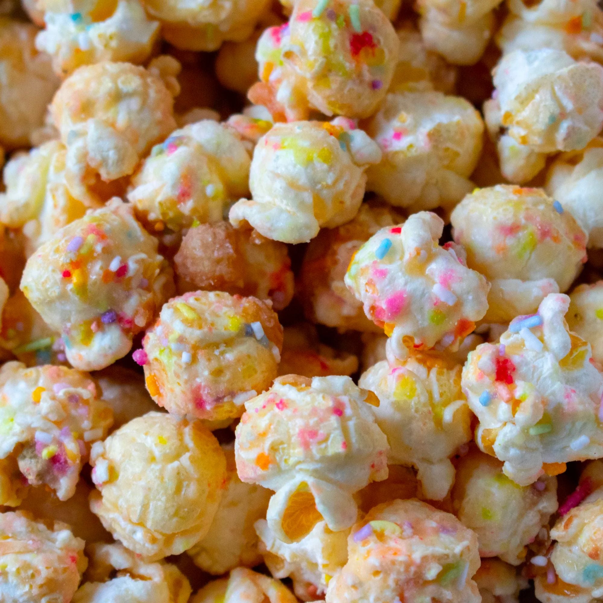 Birthday Cake Popcorn Bonanza: a festive pile of popcorn topped with colorful sprinkles, offering a delightful snack experience for celebrations. Vegetarian-friendly confectionery.