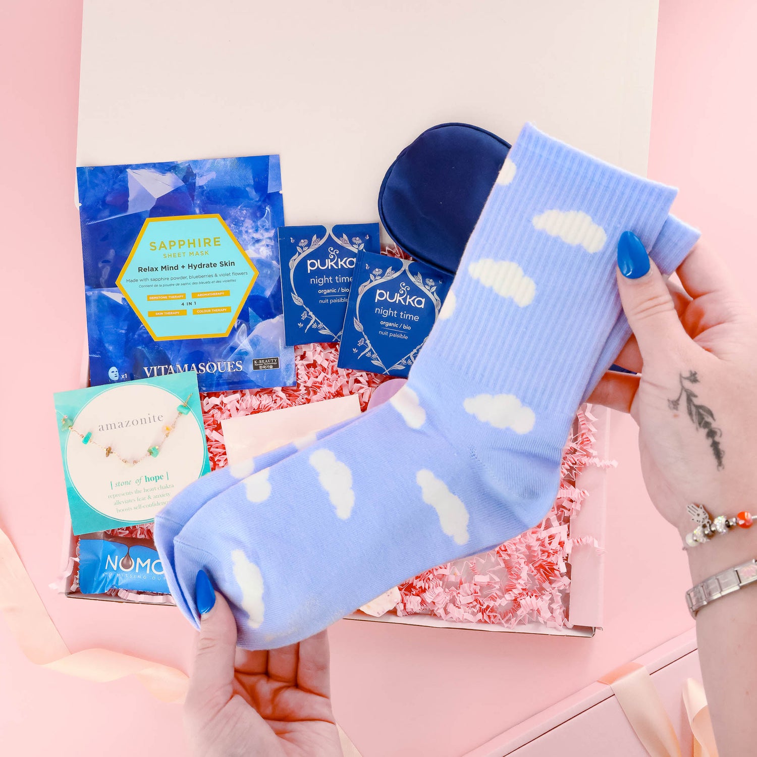 Self care gift for her with fluffy cloud socks, sleep mask, sapphire face mask, herbal teas, and a calming pamper selection – perfect for relaxation.