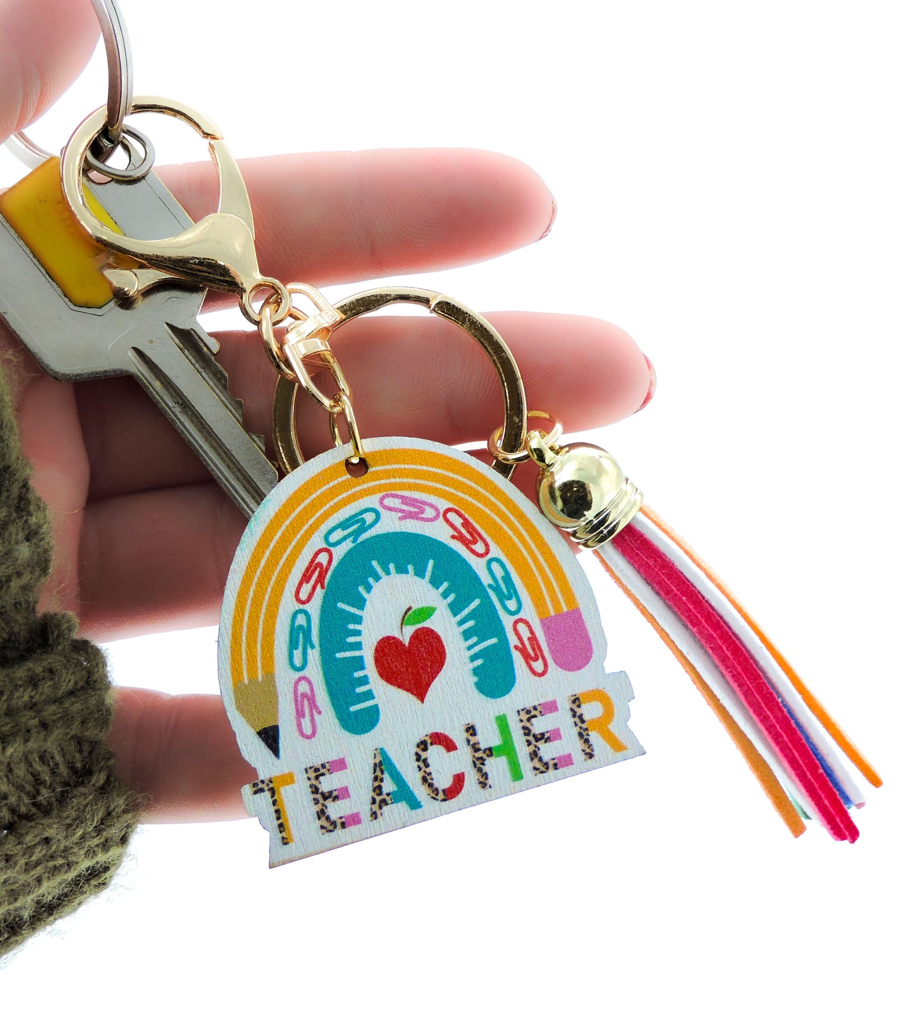 Hand holding Teacher Keyring with pencil and apple motifs, a playful design ideal for adding flair to keys or bags.
