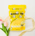 Tropical Bubble Tea Bath Salts package with a pink flower and logo, highlighting its fruity, hydrating benefits for a refreshing self-care experience.