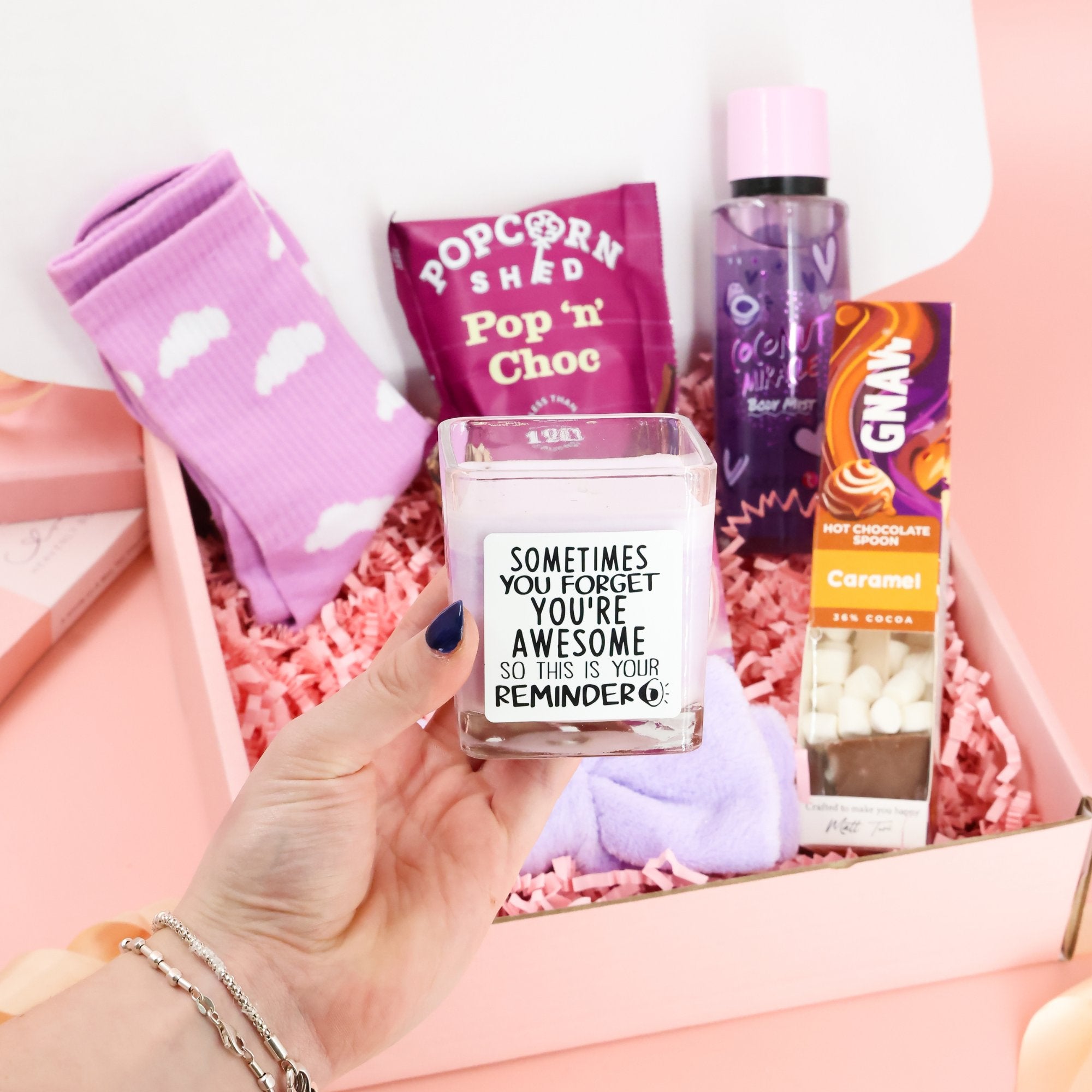 Contents of the You Are Awesome care package including organic tea, cozy socks, and a personalized motivational card plus you're awesome candle