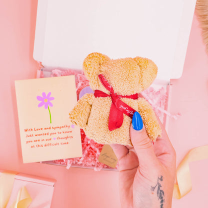 Bereavement gift for her featuring a soft teddy bear with ribbon, sympathy card, and comforting keepsakes – a thoughtful hug in a box during grief.