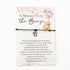 A Message from the Bump Bracelet featuring a delicate bracelet with a tiny baby feet charm on a message card, symbolizing motherhood excitement.