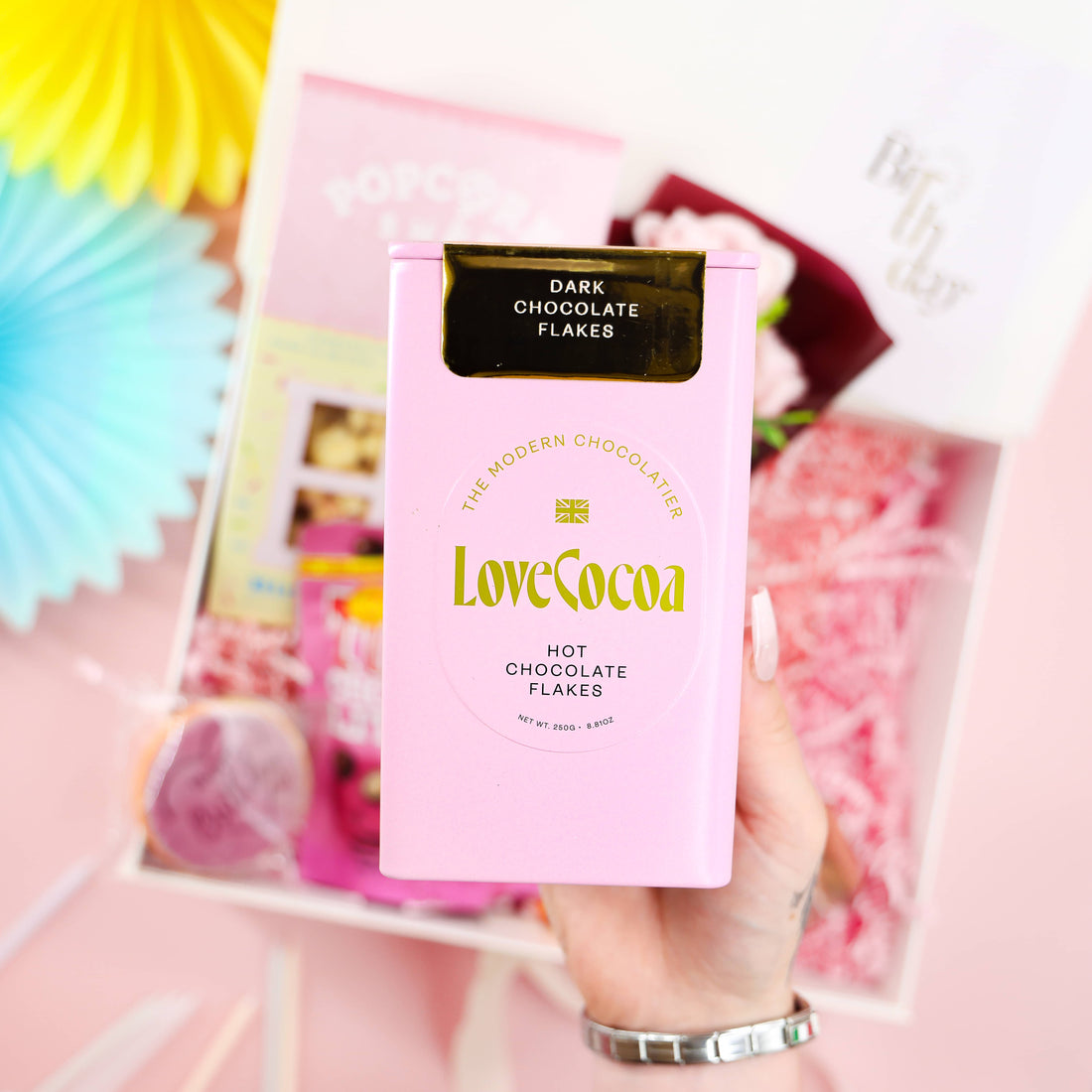 A Pretty Pink Birthday Gift Box – pink limited-edition birthday hamper with Love Cocoa hot chocolate flakes, popcorn, Tony’s chocolate, body lotion and birthday biscuit by Heavenly Boxes.