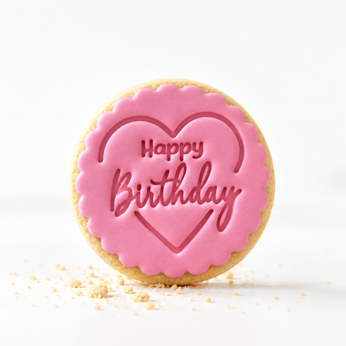 Handmade birthday cookie with pink heart design and embossed Happy Birthday message