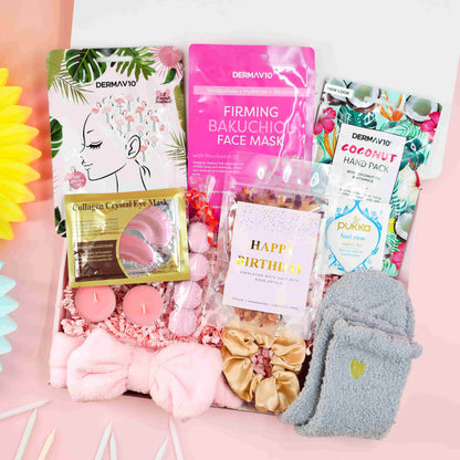 Birthday Spa Day in a Box gift set with pink headband, cosy grey socks, bath salts, tropical hair mask, firming face mask, coconut hand pack, candles, and Pukka tea – luxury birthday pamper gift for her