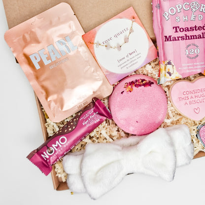 Luxury pampering gift box featuring vegan NOMO fruit crunch chocolate bar, a plush white headband, and a bath bomb with rose petals for her.