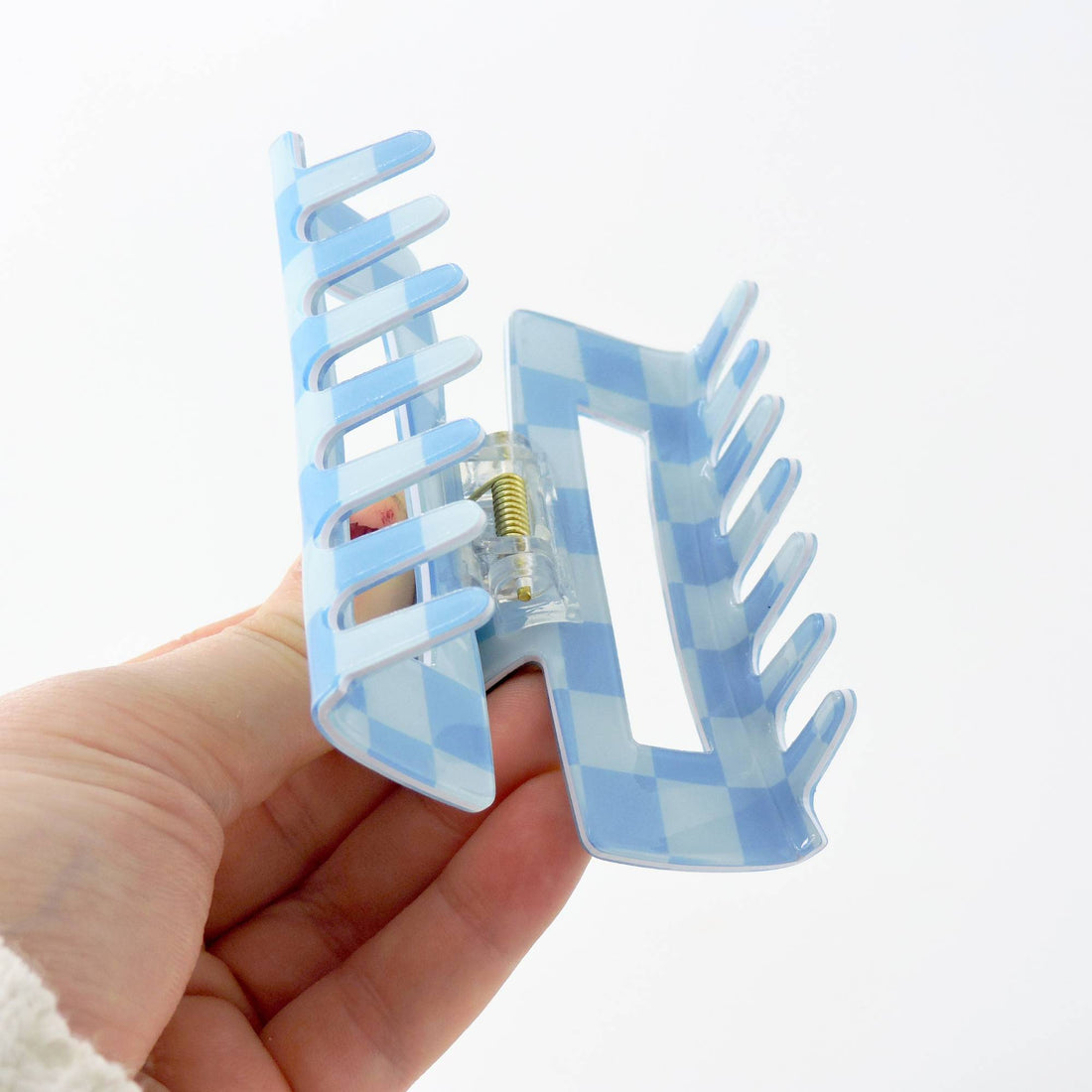 Hand holding the Blue Checkered Big Claw Hair Clip, showcasing its large grip design for secure hair styling, blending retro style with practicality.