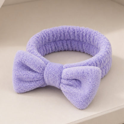 Bowknot Headband Purple: A plush, stylish headband with a bow, perfect for securing hair during beauty routines, blending functionality with fashion.