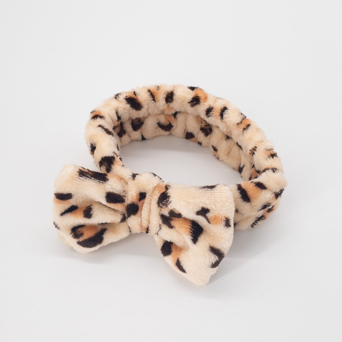 Leopard Print Bowknot Headband: A plush, versatile fashion accessory ideal for securing hair during beauty routines, combining functionality with a cute, stylish flair.