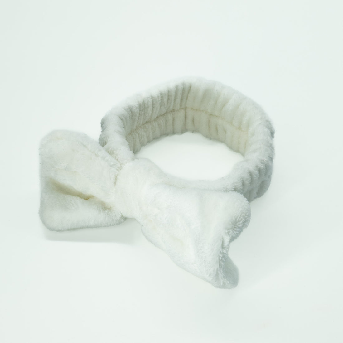 Bowknot Headband White: A plush, stylish headband with a bow, ideal for keeping hair in place during beauty routines.
