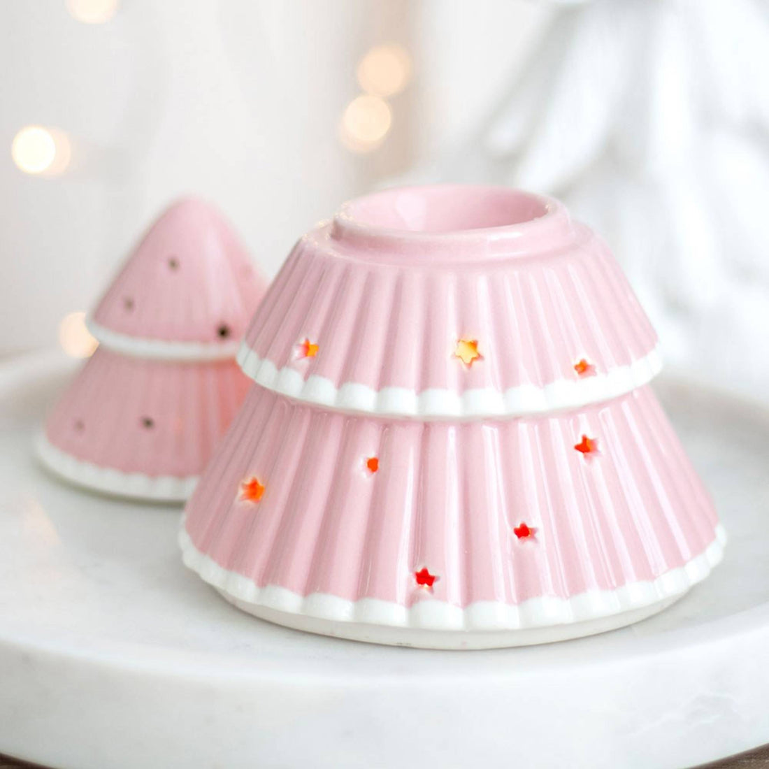 Christmas Tree Oil Burner with star cut-outs, ideal for festive décor, emits a warm glow, enhancing home fragrance when used with diluted fragrance oil.