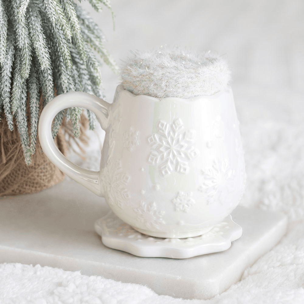White ceramic snowflake mug with matching coaster and fluffy winter socks