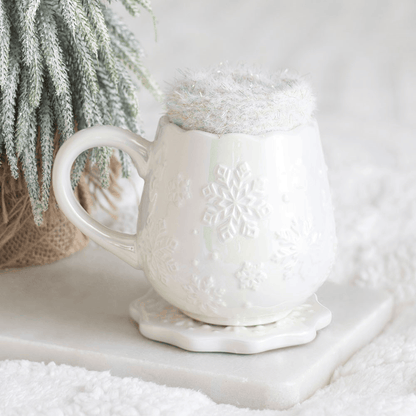 White ceramic snowflake mug with matching coaster and fluffy winter socks