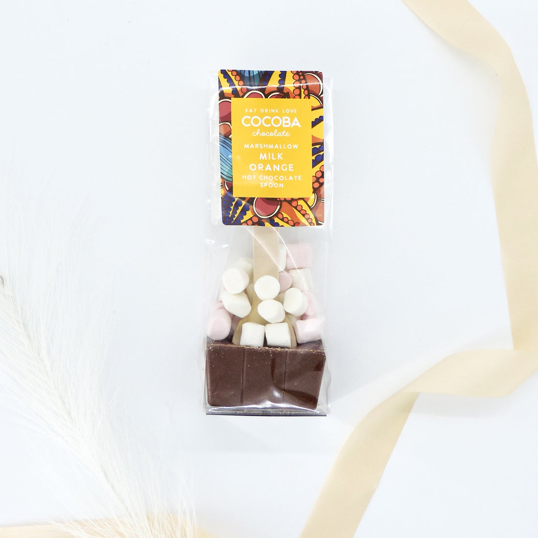 Cocoba Milk Orange Hot Chocolate Spoon with marshmallows, perfect for cozy indulgence or gifting, displayed with chocolate and marshmallow packages.