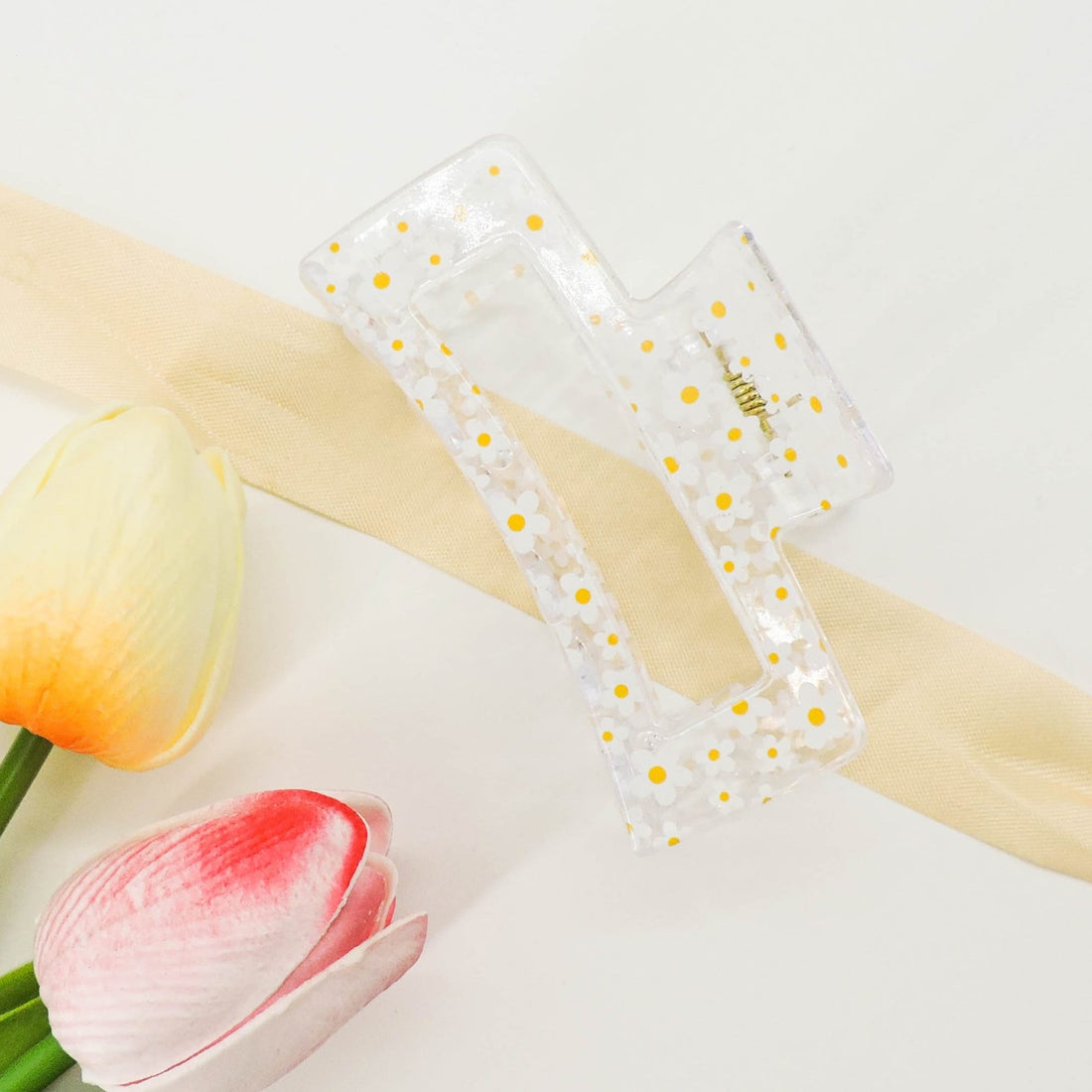 Daisy Print Hair Clip featuring a chic claw design, adorned with a daisy pattern, perfect for securing hair with elegance and a playful touch.