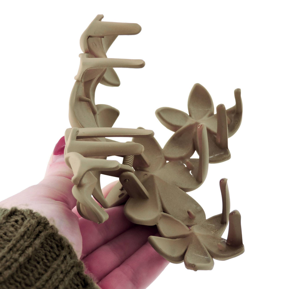 Floral Hair Clip - Brown Beige: A hand holds an elegant matte flower hair clip with a layered floral design, perfect for enhancing any hairstyle.
