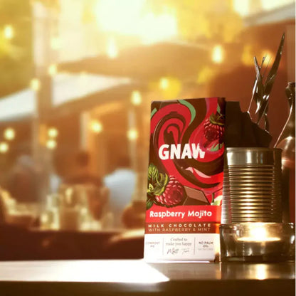 GNAW Raspberry Mojito chocolate bar on a bar counter with blurred bar background