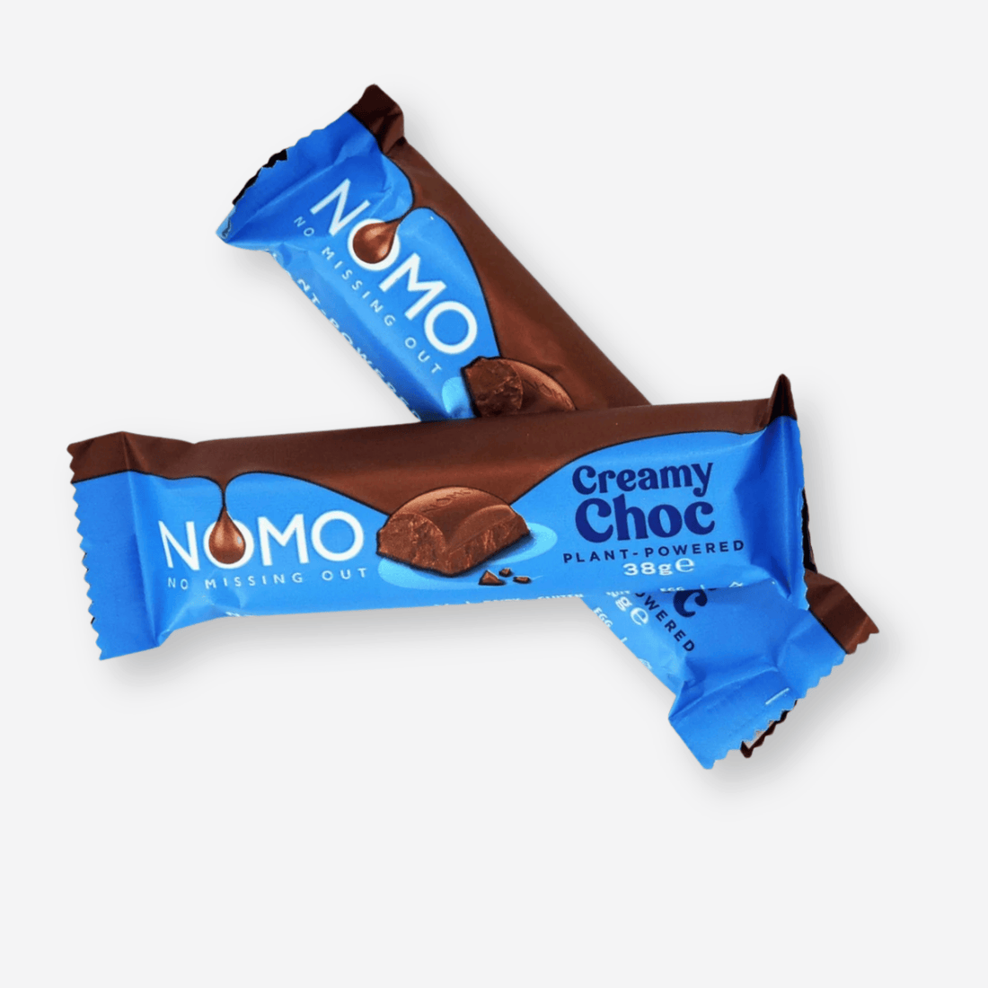 NOMO Creamy Choc - 1pc: Close-up of the smooth, dairy-free chocolate bar with a visible blue label, highlighting its allergen-friendly, plant-powered ingredients.