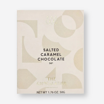 The Chocolatier Salted Caramel Chocolate bar in elegant cream packaging with abstract shapes and pale gold ribbon, perfect for gifting and indulgence.