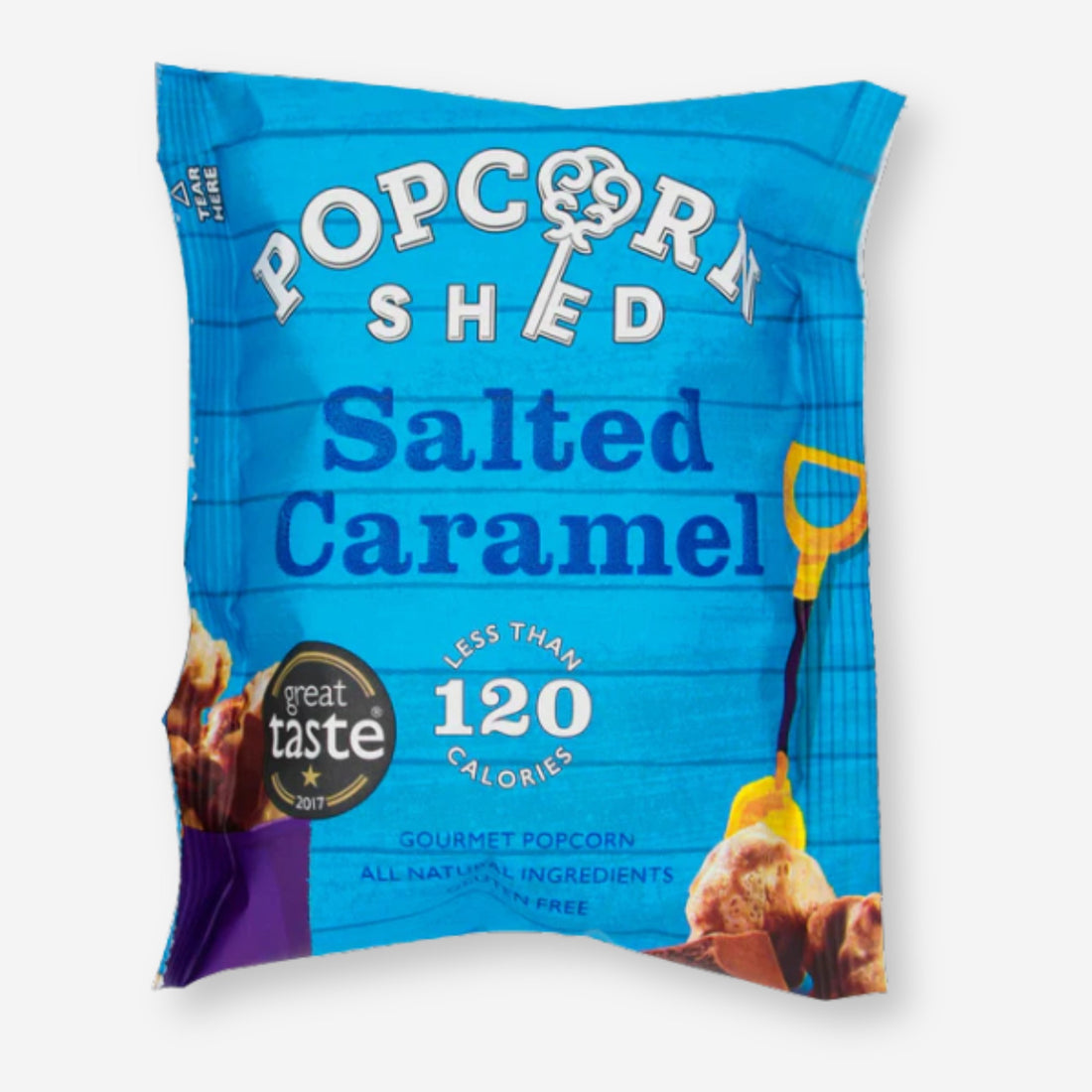 Popcorn Shed Salted Caramel packaging with a prominent logo, showcasing gourmet popcorn made with sea-salted caramel and creamy Belgian milk chocolate. Suitable for vegetarians, gluten-free.