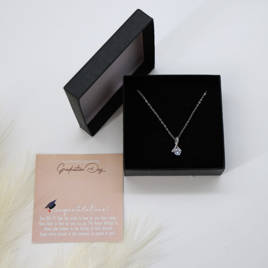 Graduation Day Necklace: Silver chain with teardrop crystal pendant, elegantly detailed, presented in a gift box for a memorable milestone.