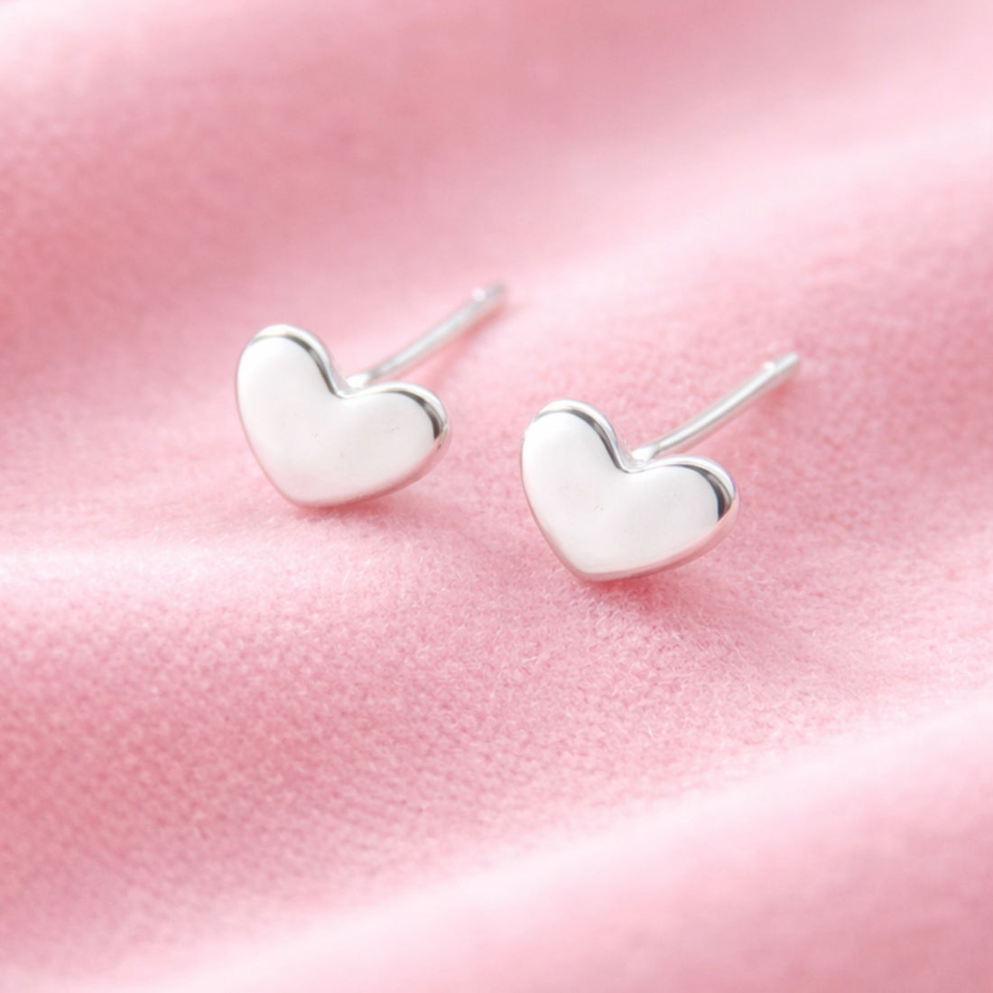 Heart Earrings: Delicate, heart-shaped stud earrings with a minimalist design, perfect for layering or wearing solo, adding elegance to any look.