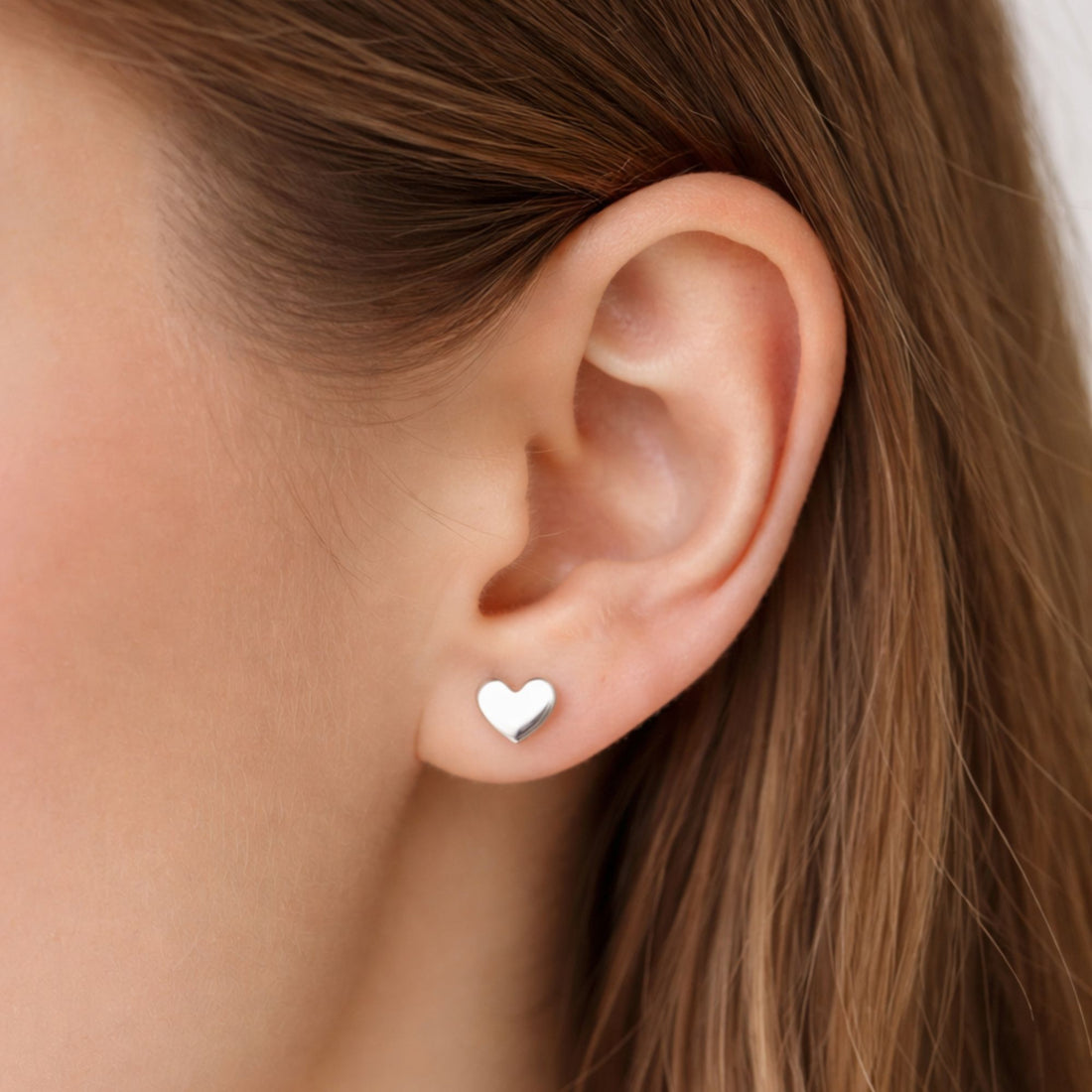 Heart Earrings: Delicate, heart-shaped stud earrings with a minimalist design, perfect for layering or wearing solo, adding elegance to any look.