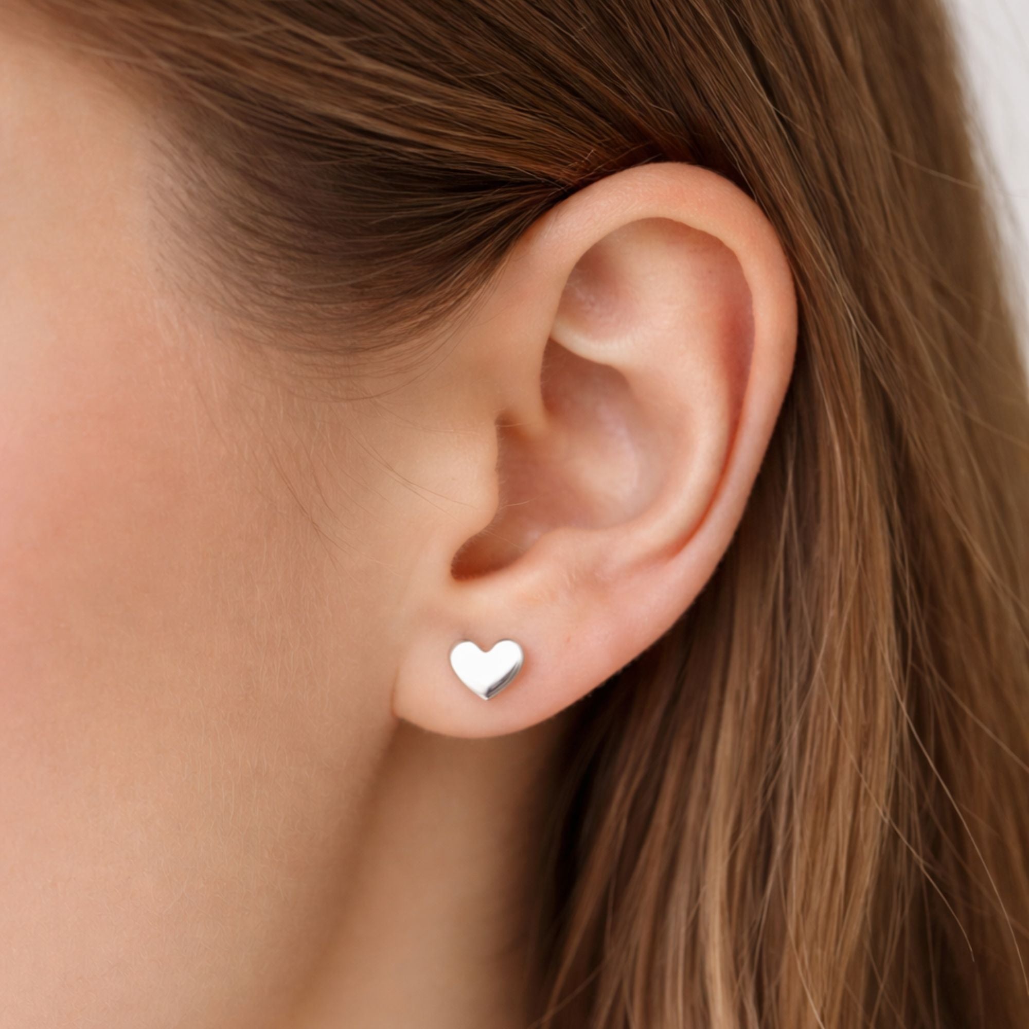 Heart Earrings: Delicate, heart-shaped stud earrings with a minimalist design, perfect for layering or wearing solo, adding elegance to any look.