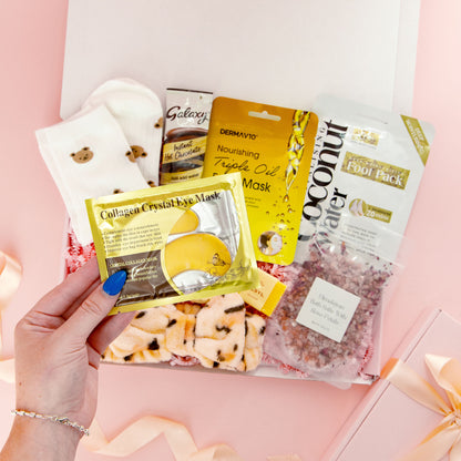 Luxury self care gift for her featuring collagen eye mask, bath salts, hot chocolate, cozy socks and spa treats – perfect relaxation gift box.