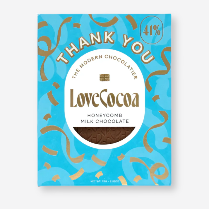 Love Cocoa Thank You Chocolate featuring a close-up of a decorative yellow ribbon, letter Y, and a blue and gold candy wrapper, ideal for gifting.