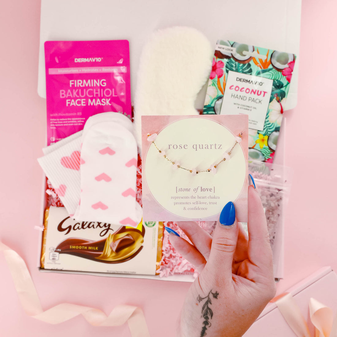 Thoughtful self care gift for her with rose quartz bracelet, heart socks, face mask, chocolate, and spa treats – perfect wellness gift box for women.