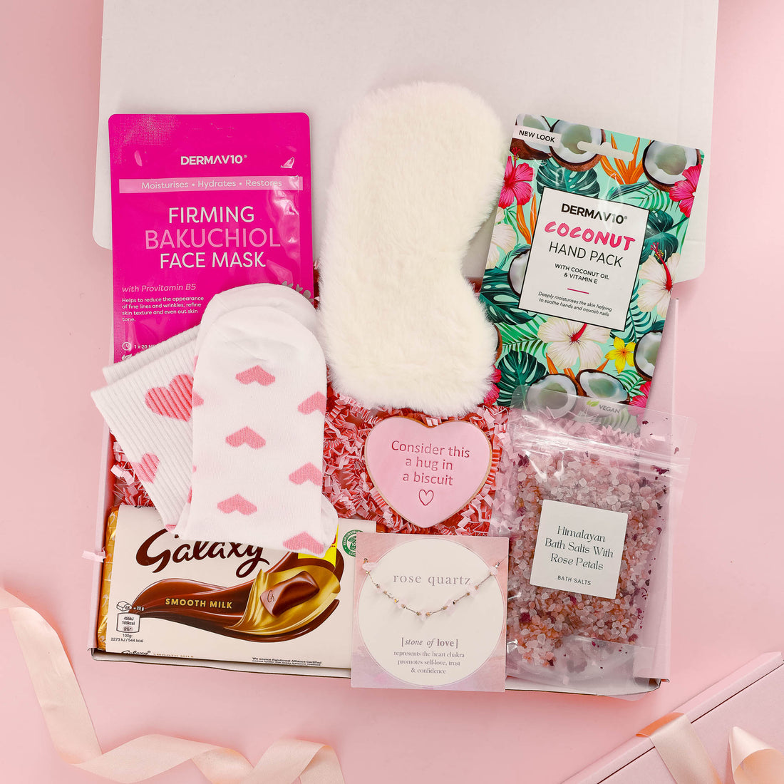 Luxury gift for her with face mask, coconut hand pack, pink heart socks, bath salts, Galaxy chocolate, eye mask, and rose quartz bracelet – complete self care gift set.
