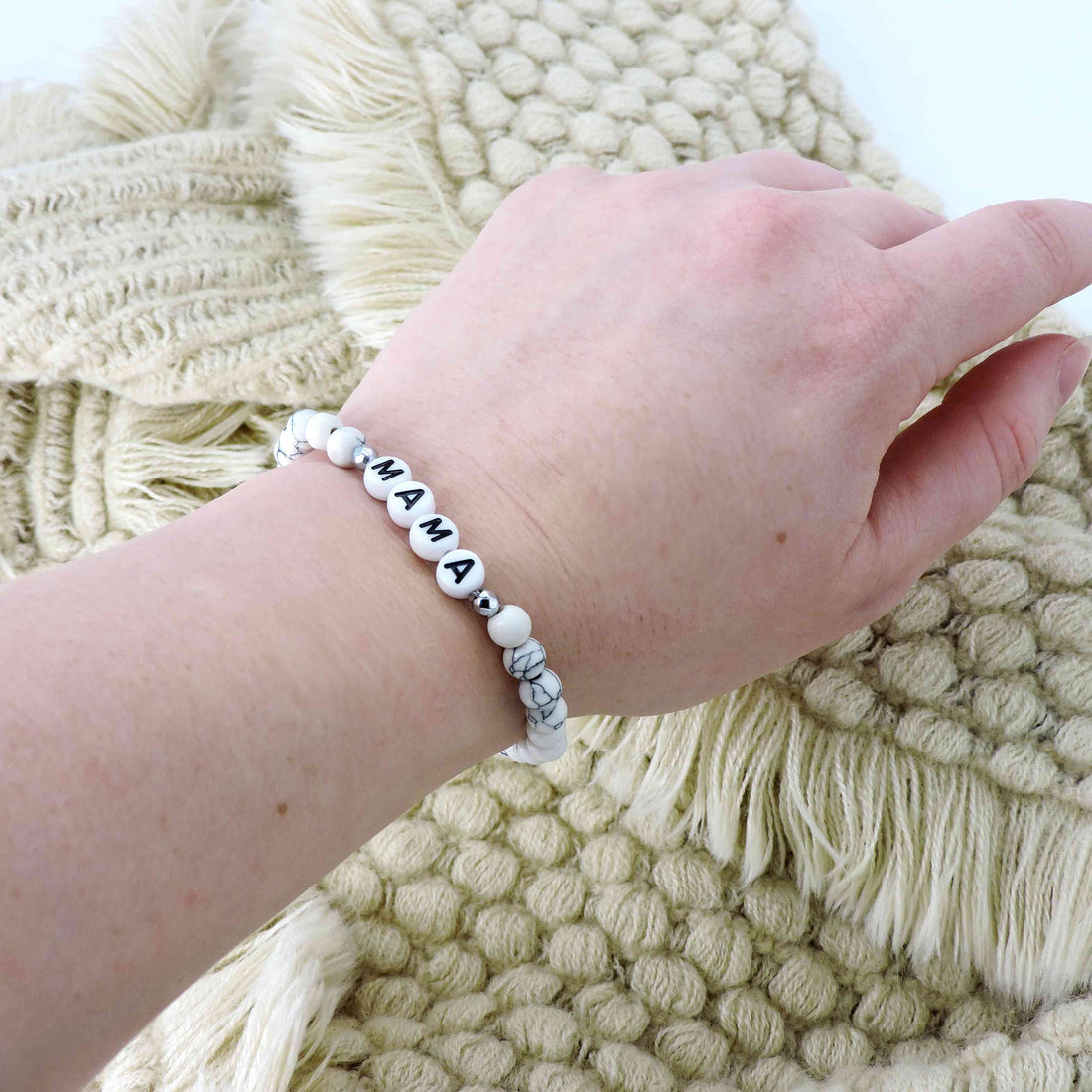Mama Bracelet with white marbled beads and black letter charms, designed as a stretch-fit fashion accessory celebrating motherhood. Ideal gift for moms and mothers-to-be.