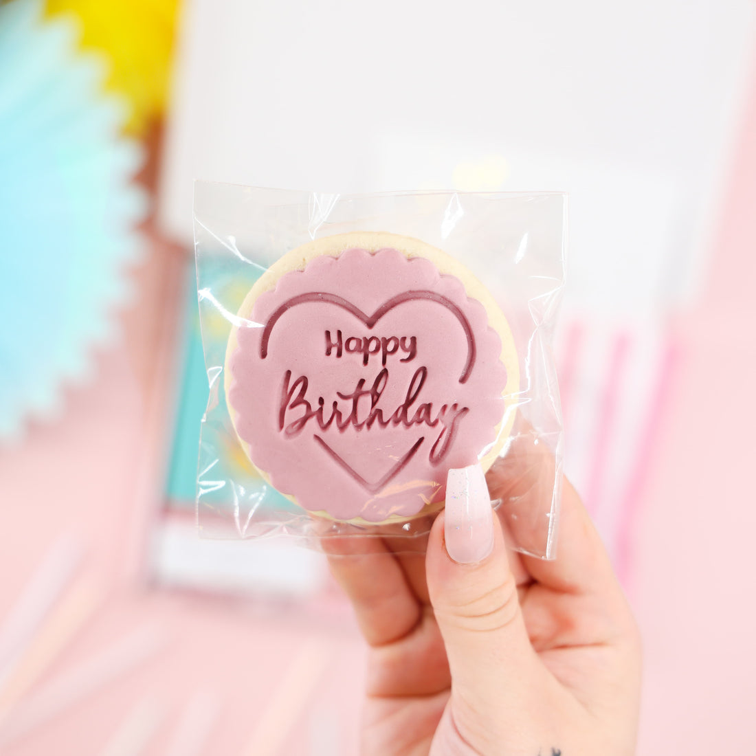 Close-up of iced Happy Birthday biscuit in pink heart design – part of the Mini Birthday Indulgence Gift Box.