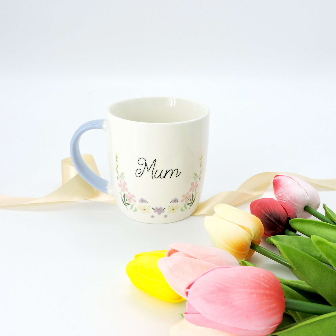 Mum Ceramic Mug - Floral Design, featuring a delicate floral pattern and pastel blue handle; perfect for showing appreciation to mums.