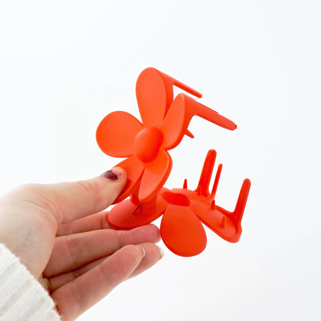 Close-up of a hand holding the Orange Matte Flower Large Hair Clip, showcasing its bold, playful design, perfect for adding charm to any hairstyle.
