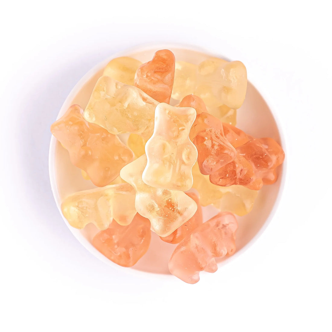 Prosecco Gummies - Non Alcoholic, a close-up view of a bowl filled with gourmet gummy bears infused with peach, green apple, and floral notes.