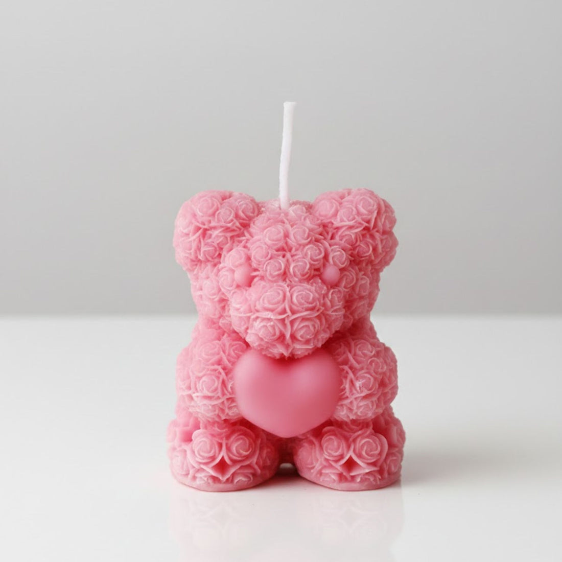 Decorative pink teddy bear candle handcrafted with miniature rose patterns holding a heart, a unique floral-scented gift for birthdays or anniversaries or Mothers day.