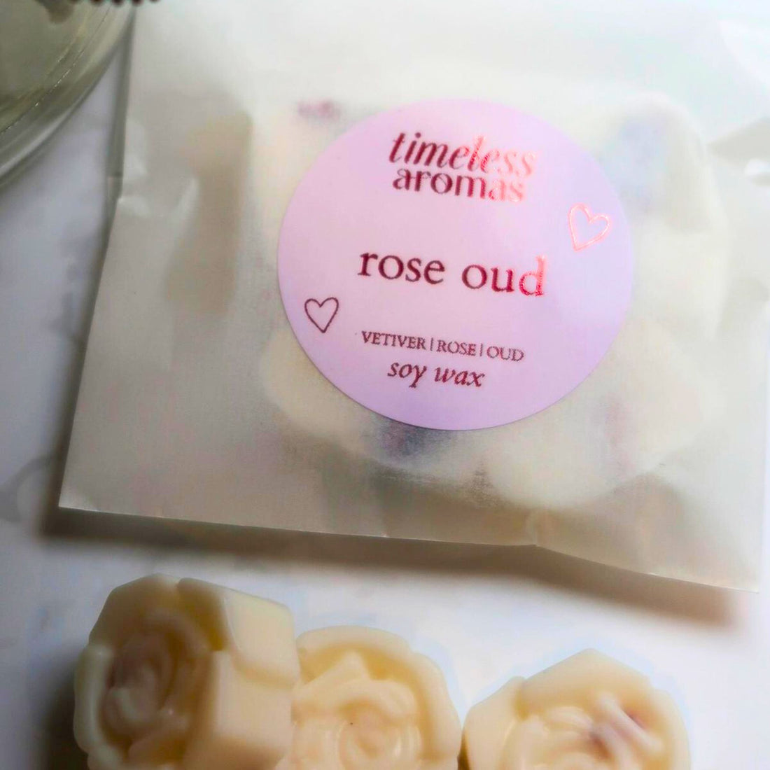 Rose Oud Wax Melt: Close-up of four hand-poured soy wax melts, featuring a luxurious oriental floral scent with notes of rose, oud, and jasmine.