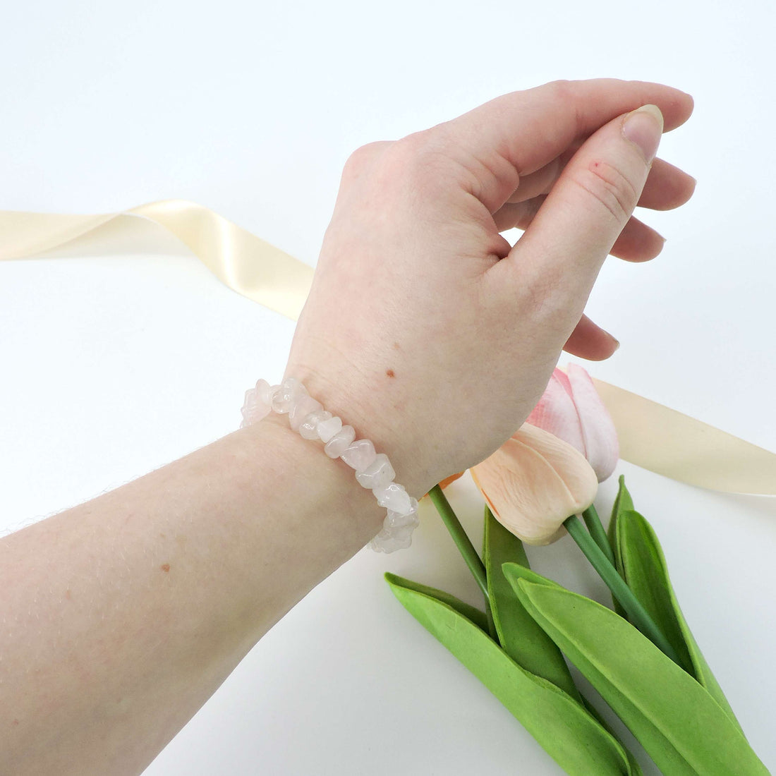 Rose Quartz Crystal Chip Bracelet on a wrist, showcasing delicate crystal chips, designed to promote self-love and emotional healing.